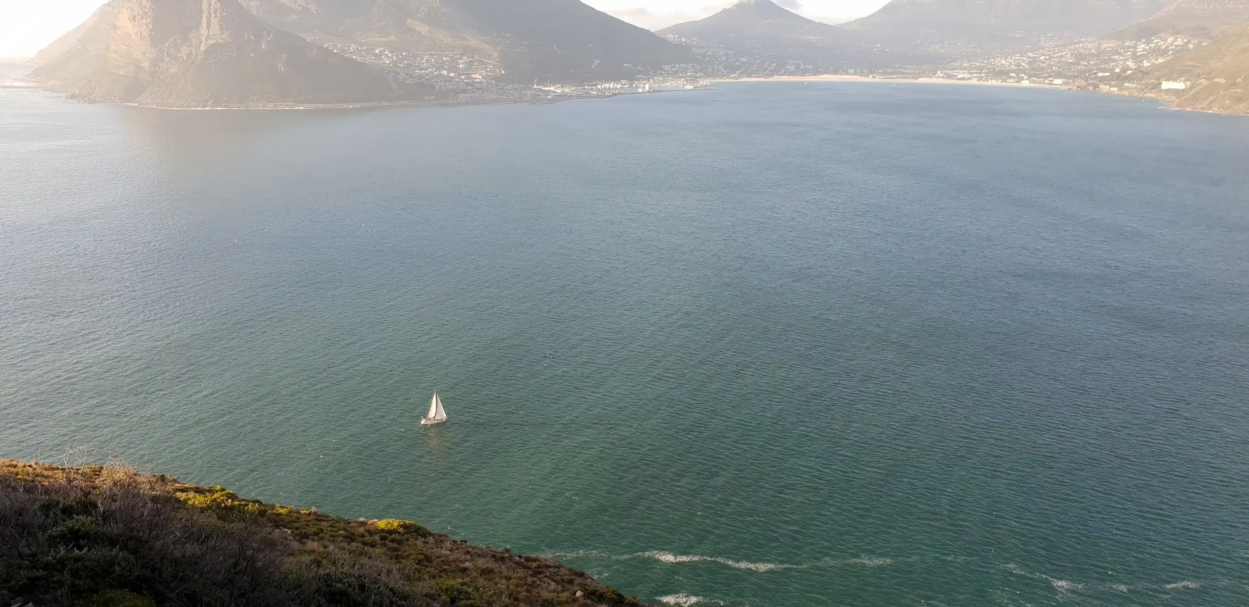 Scenic view of the ocean with a sailing yacht.